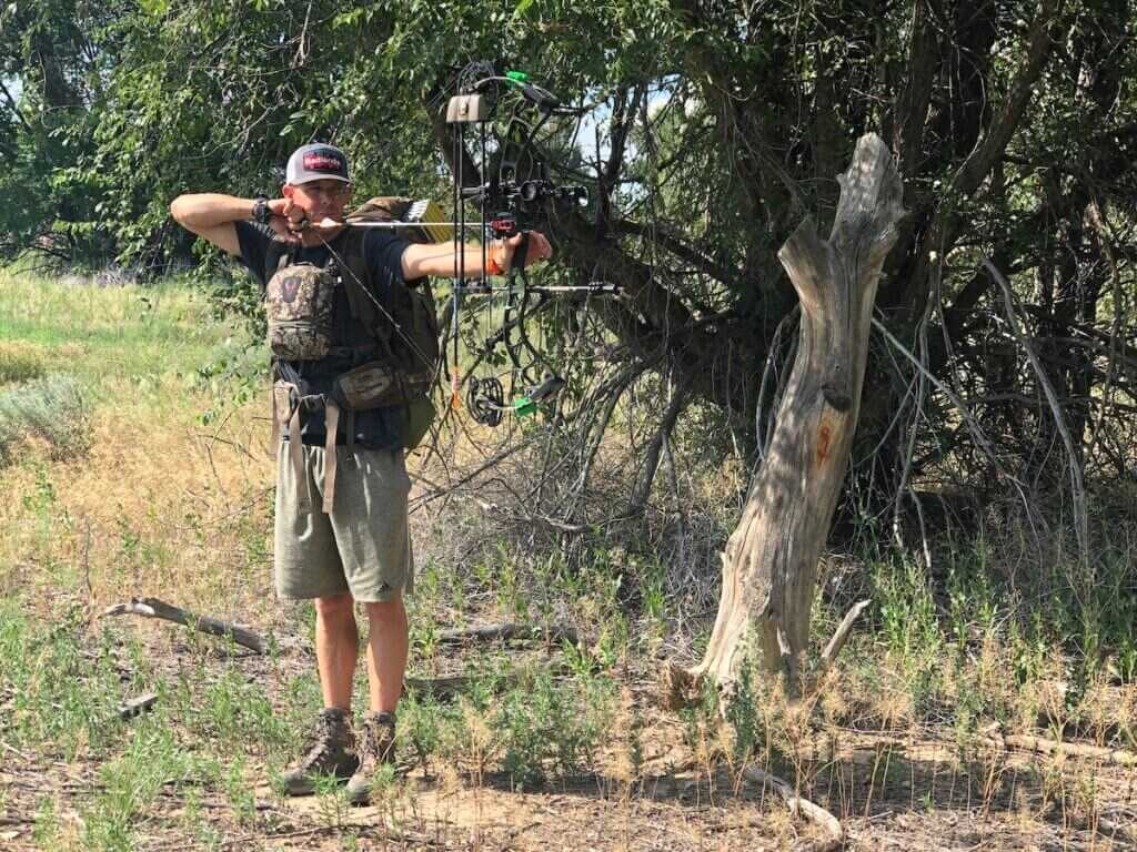 man shooting compound bow