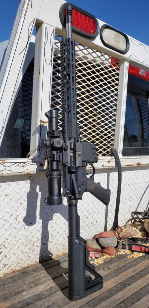 AR-15 chambered in 350 Legend leaning on a truck for straight-wall cartridge hunting