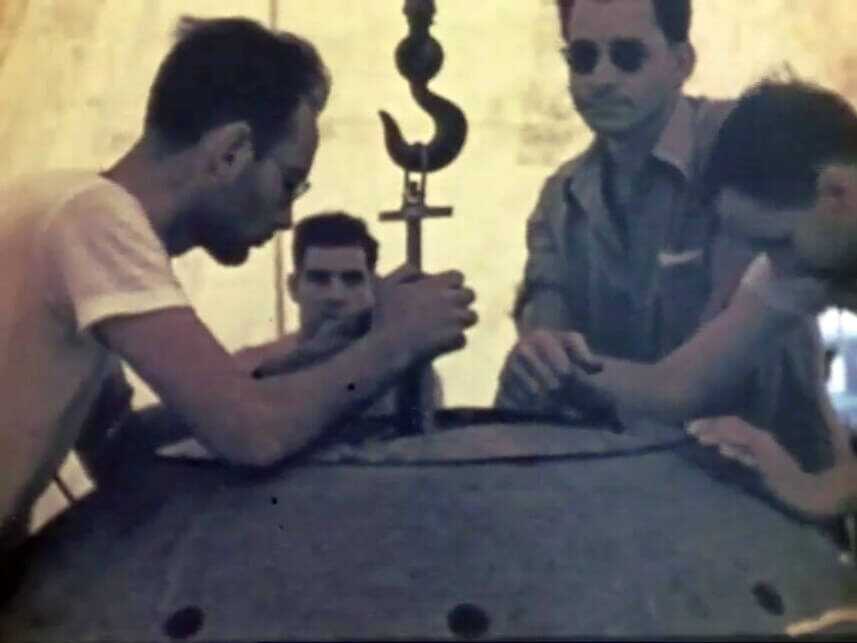 Physicists Louis Slotin and Harry Daghlian pose with colleagues while assembling a nuclear device during Manhattan Project work