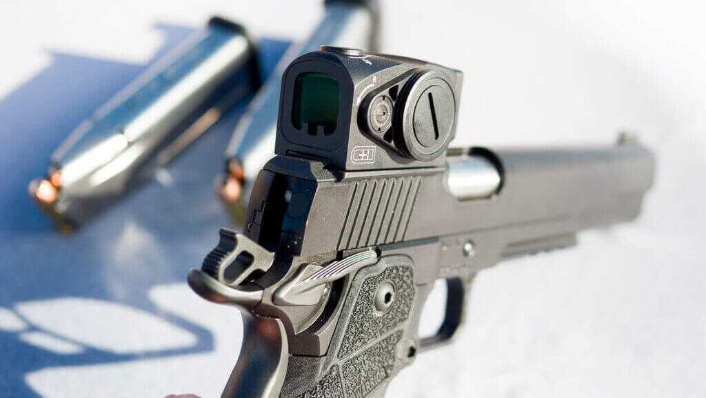 The back of the gun with the hammer cocked, showing the red dot optic mounted to the slide.