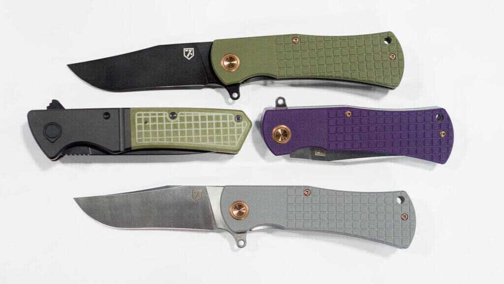 four blades laying on a table, two of them are folded, two are open.