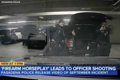 A Pasadena police officer points a handgun toward a patrol vehicle inside a department parking garage moments before an accidental shooting during what officials described as firearm horseplay involving loaded weapons.