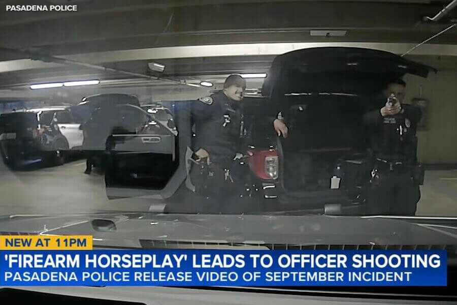 A Pasadena police officer points a handgun toward a patrol vehicle inside a department parking garage moments before an accidental shooting during what officials described as firearm horseplay involving loaded weapons.