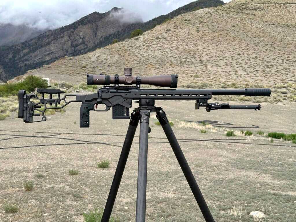 Savage 110 RF Elite Precision suppressed .22 LR rifle on a tripod with mountains in the background