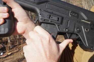 The rocker behind the mag drops the bolt.