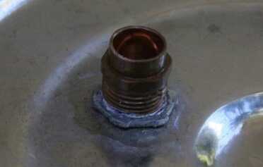 Prepping 101: Water Distillation Still -Is it Worth the Trouble? The inside of the cover has no nut but he puts one on the outside. This locks it and provides enough leak protection. This is not sealant it is corrosion because this was left outside for a long time to see if it would damage it.