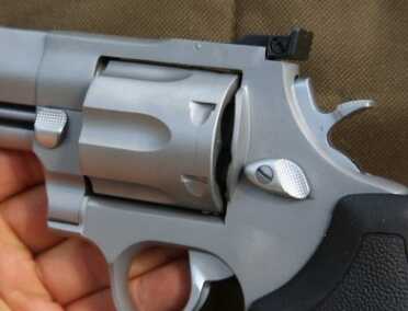 Taurus Raging Bull .44 Mag Revolver - Return of the Classic Model 444 The big revolver has two cylinder lock releases.