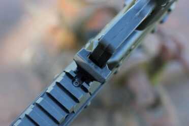 The stock lever, in front of the trigger guard. 