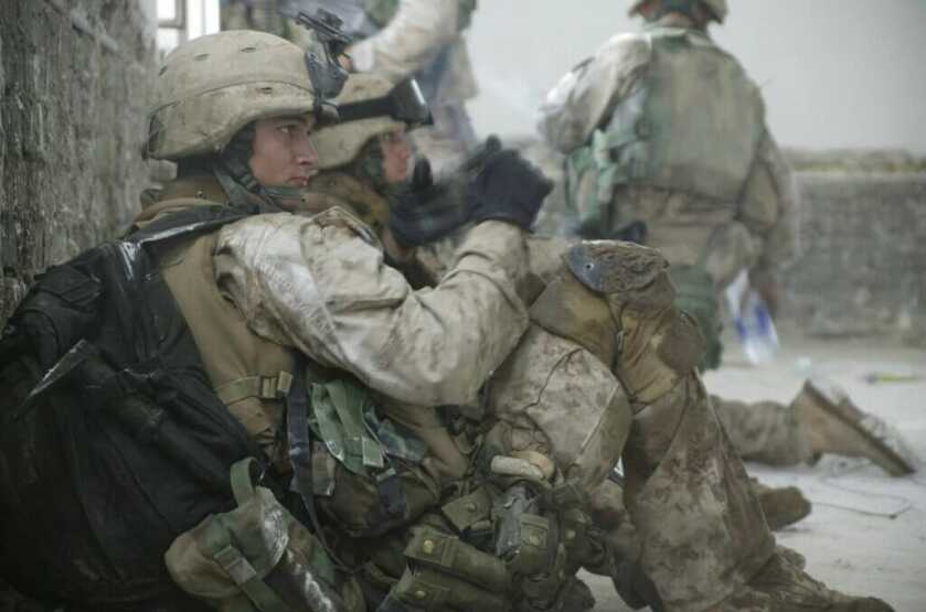 SSG David Bellavia in full soldier gear sitting behind a stone wall