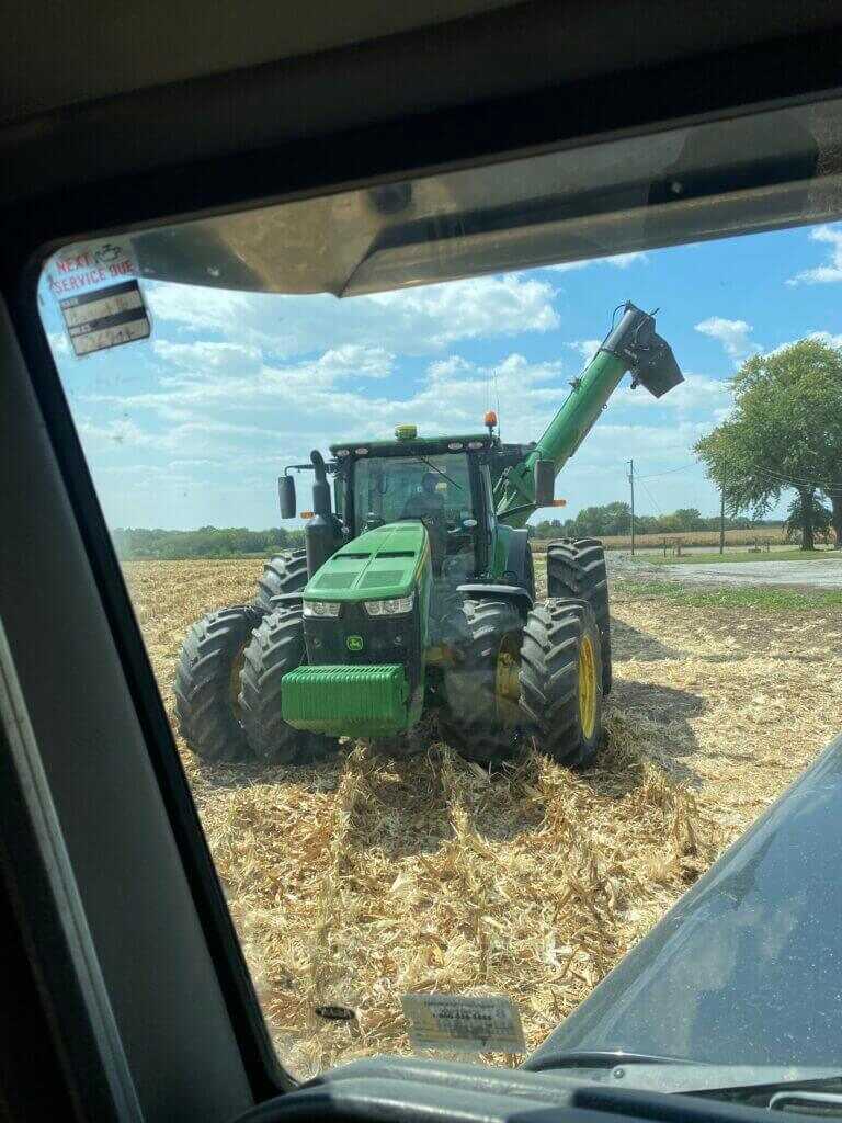 tractor and grain cart loading corn during harvest for private land access through farm work
