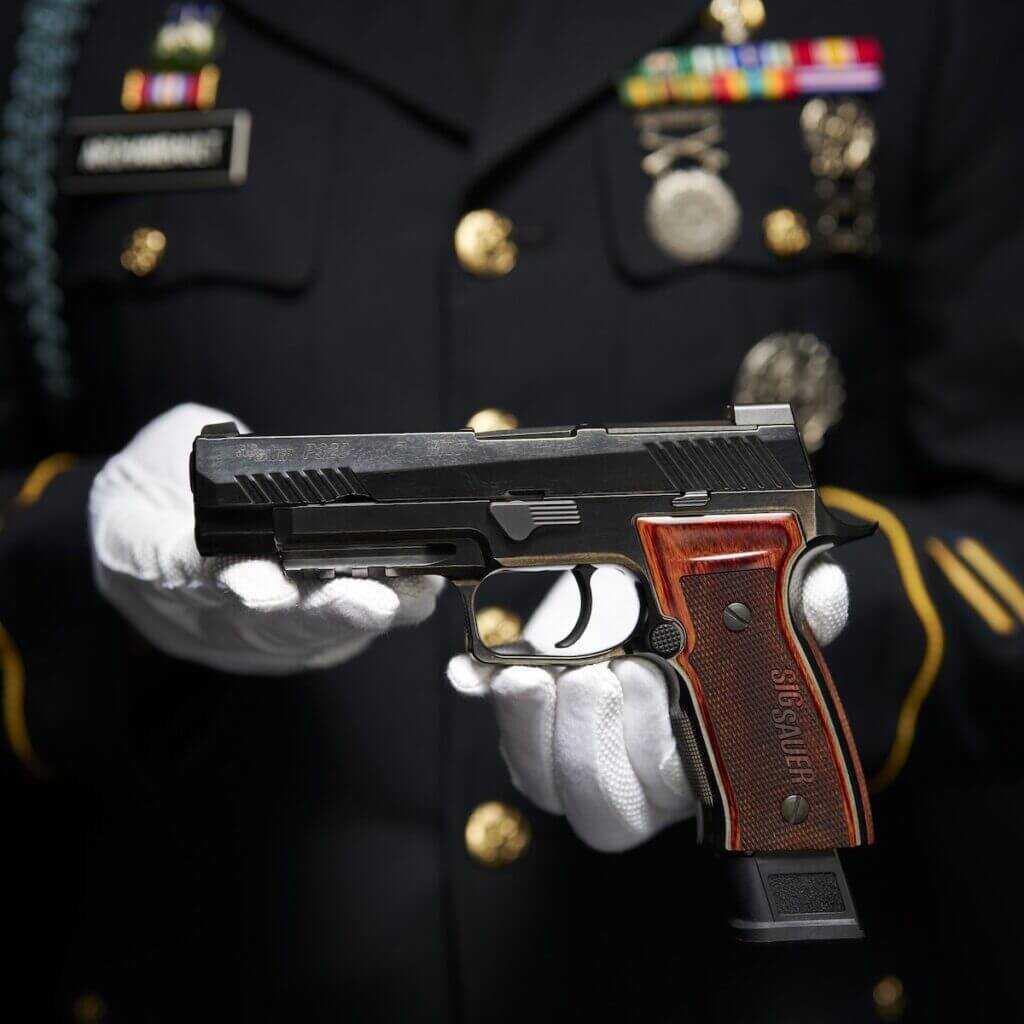 A soldier holding a SIG P320-M17 Ceremonial.