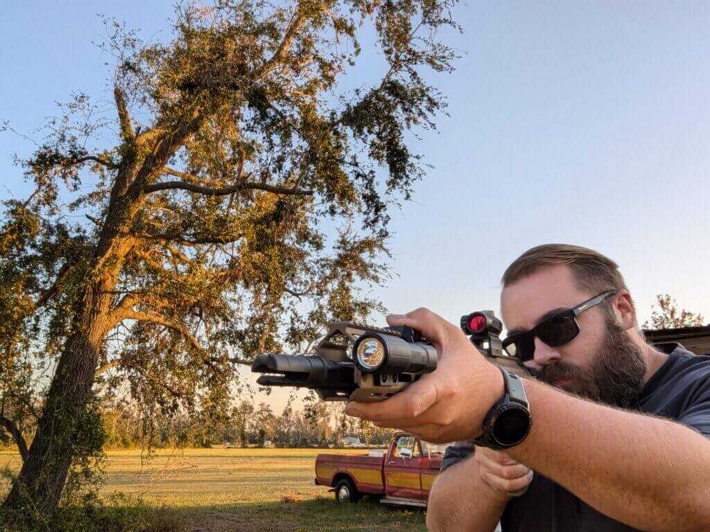 Shooter using a pressure switch on the SIG Foxtrot-MSR rifle light during aiming