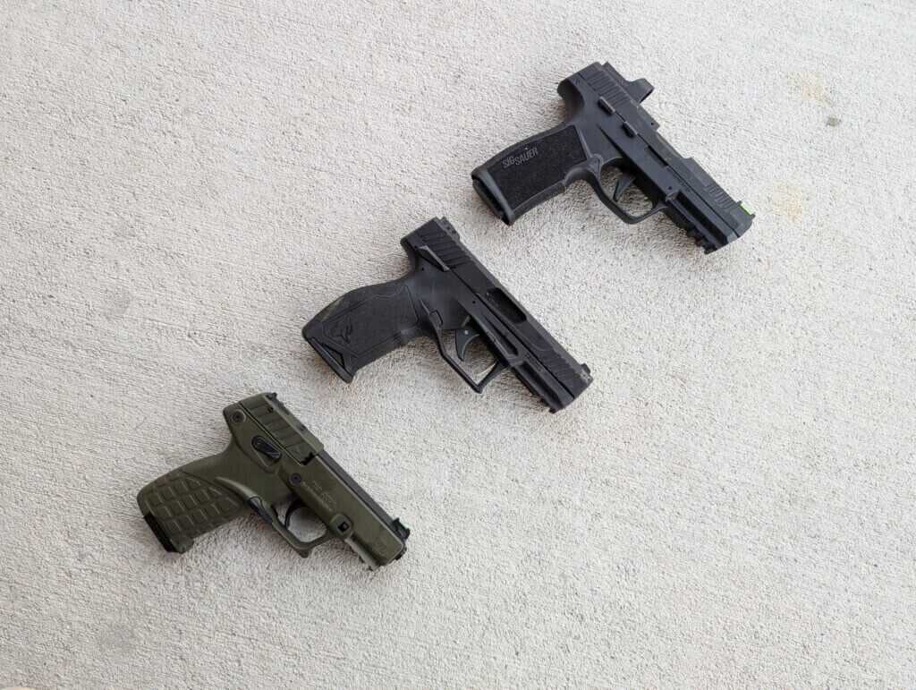 Three semi-automatic pistols on cement