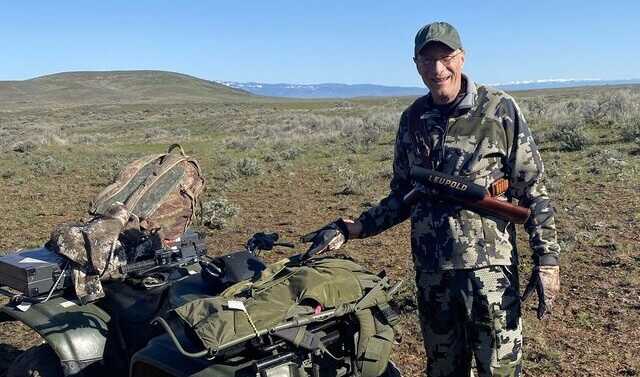 mark hampton standing outside near a 4 wheeler wearing camo