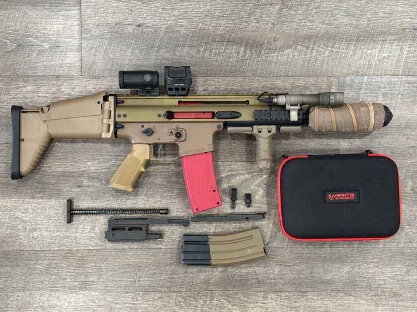 A gun with a red BlackbeardX training device installed is pictured with the removed parts below it.