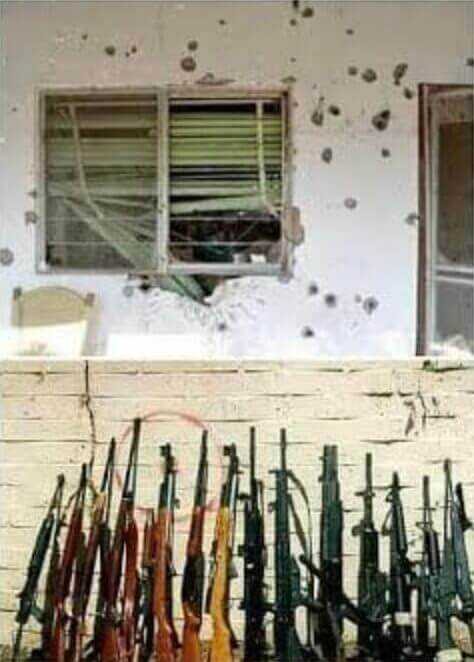 home of Alejo Garza Tamez with visible bullet holes and a row of guns in front