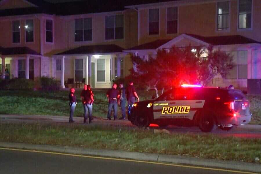 Picture of a police car and officers at the scene of the shooting.