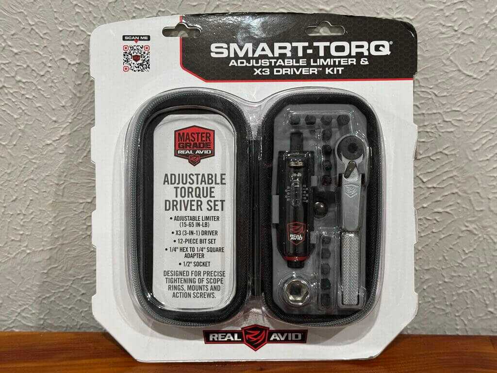 The packaged wrench set sits on a wooden bench against a white wall.