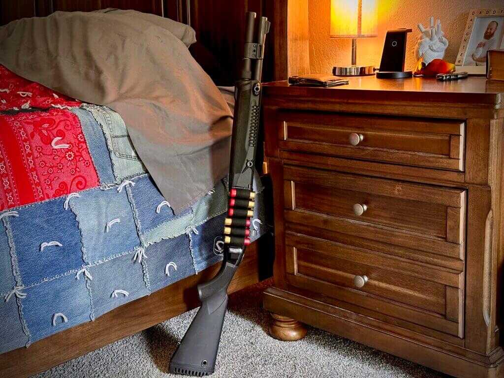 The 940 Pro Tactical SPX is propped up between a black walnut bed and nightstand.