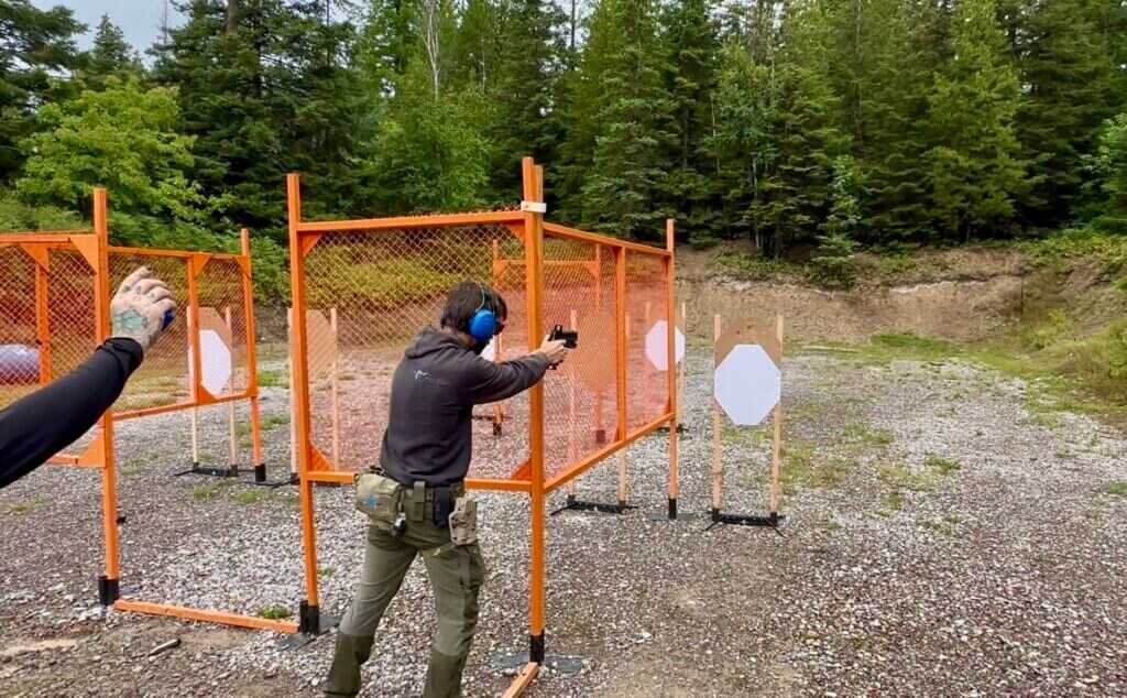 A man is shooting a gun at the range.