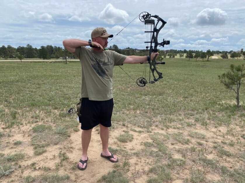 mand standing with bow. index-finger release