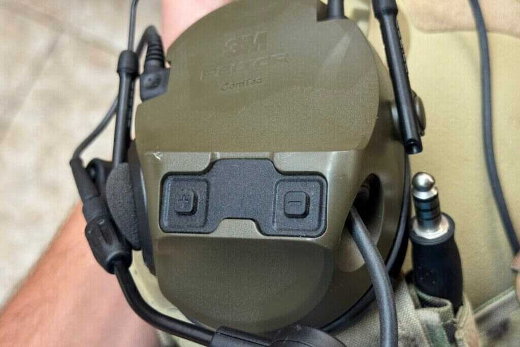 Two button controls on ComTac VIII earcup showing power and volume for ambient sound amplification