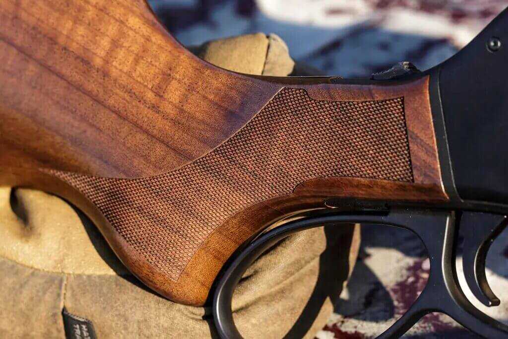 Close-up of Henry Lever Action Supreme pistol grip showing deep-cut diamond checkering on walnut
