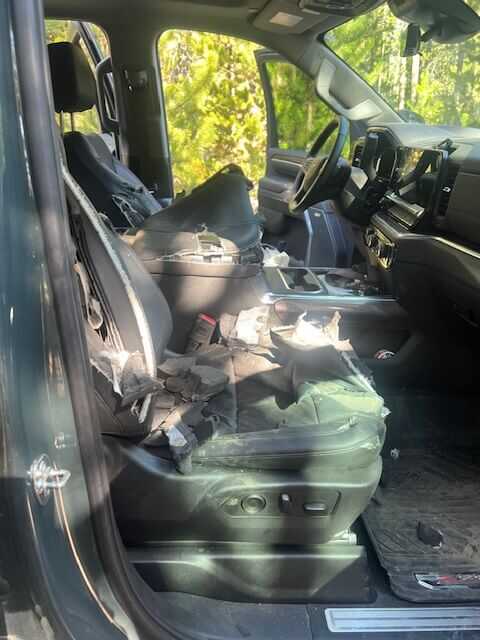 Shredded 2025 Chevrolet Silverado 2500 HD after black bear break in at Montana trailhead, driver side torn open