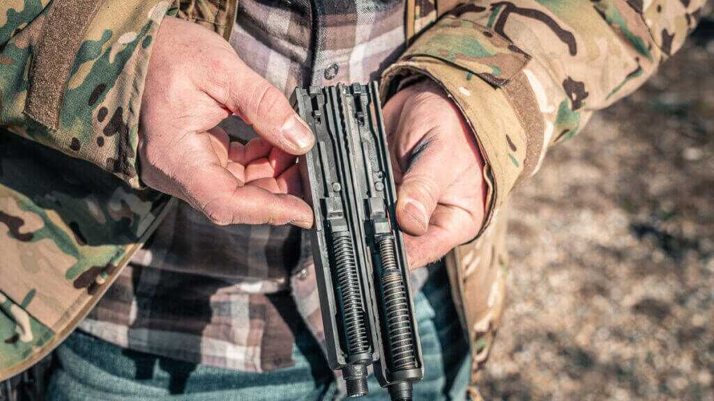 Dual recoil spring assembly of the SAR9 SOCOM next to another spring