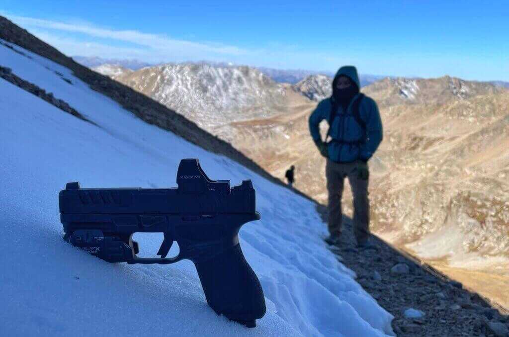 Echelon 4.0C compact 9mm resting in fresh snow on Colorado mountainside with gloves