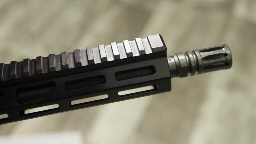 The end of the rifle showing the pic rail and a2 flash hider.