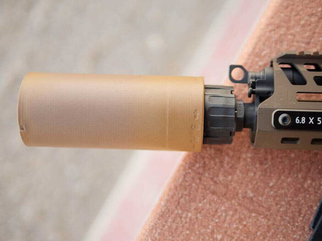 Close up of the shorter suppressor attached to the barrel.