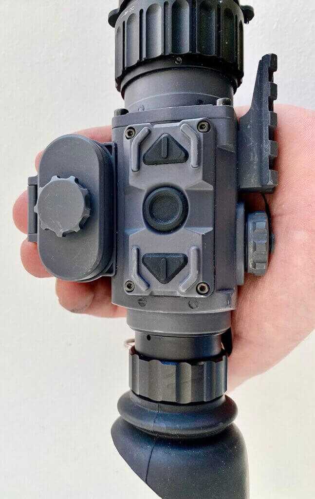 Armasight Warden 640 thermal monocular in hand showing three-button controls and battery compartment