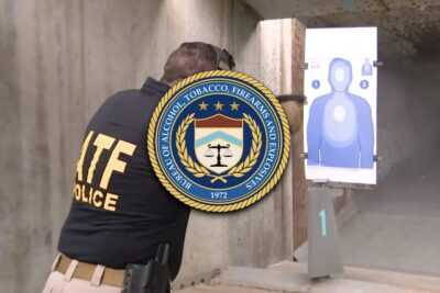An ATF agent shooting at a indoor gun range.