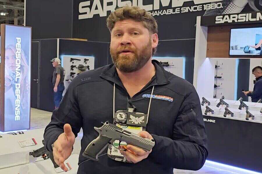 Managing Editor True Pearce at SHOT Show 2026 holding a pistol.