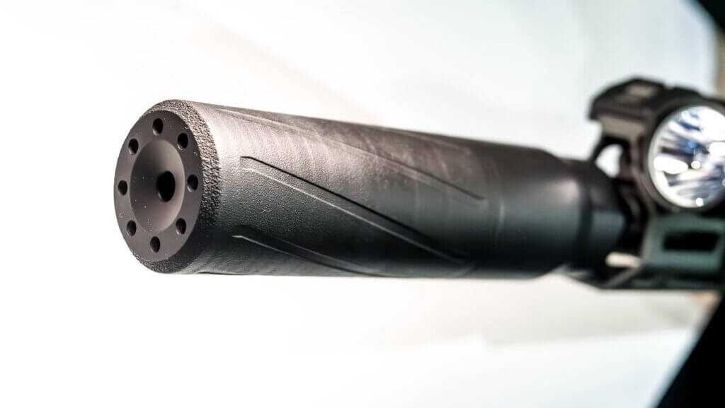 Close up of the end of the suppressor with it attached to a rifle.