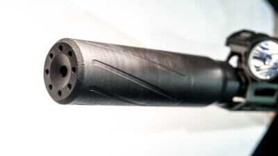 Close up of the end of the suppressor with it attached to a rifle.