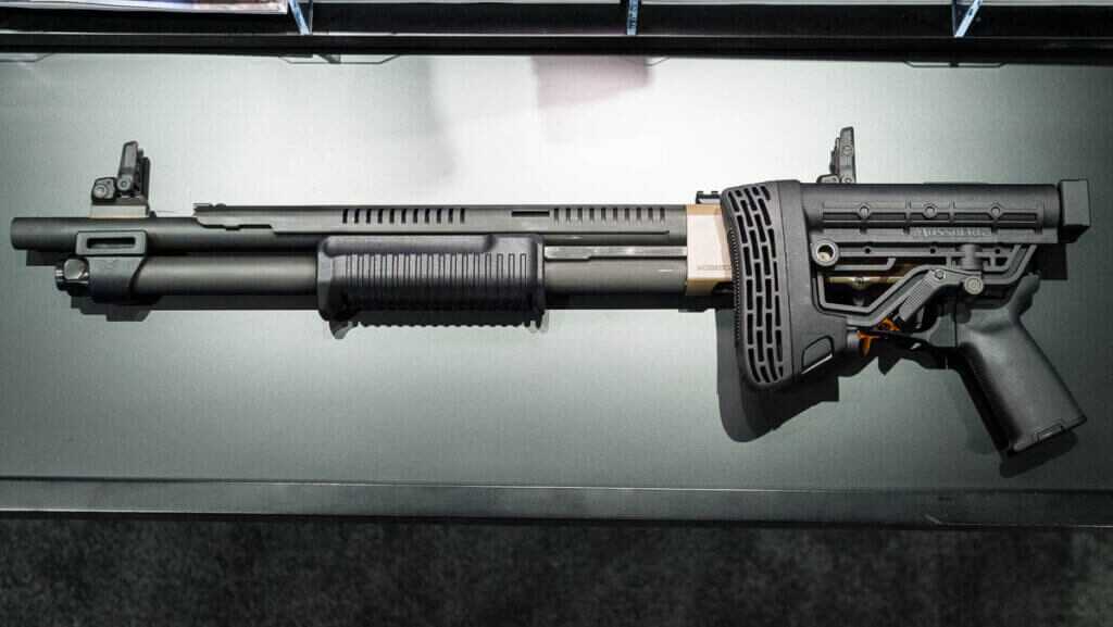 The whole gun with the stocked folded sitting on a table pointing to the left.