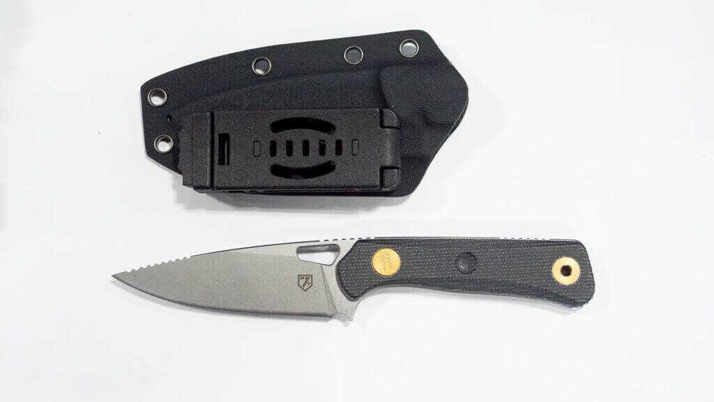 The whole knife on a white table with sheath.