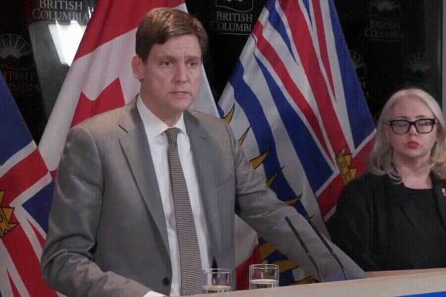 A Canadian official talks about the mass shooting in Canada at a podium.