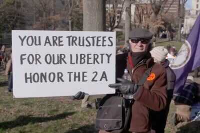 A man holding up a pro-2A sign.