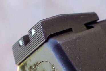 The rear sights combine flat black serrations and small whit dots. 