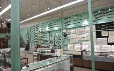 Selling History-Cohen and Sons of New Orleans Guns on the walls, coins in the cases. They sell antique maps too.