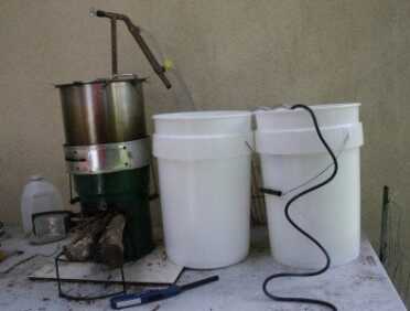 This is my full setup with the 3 gallon still, my StoveTec Rocket Stove, and both a collection bucket and cooling water bucket. 