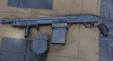 This is the Adaptive Tactical Sidewinder Venom kit installed on a FLEX Mossberg 500 6 shot shotgun. The 5 round straight mag is on the gun and the 10 round rotary mag is on the mat. 