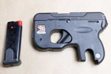 The long cuts in the grip are where you index the mag. Squeeze the mag's sides and pull it out. No button to push.