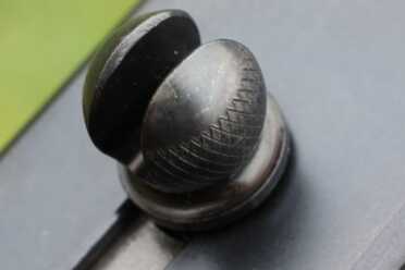 The charging knob is on top, and split so you can see through it. This split also functions as a fast sight for close work. 