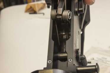 STEP 6: Install hammer into receiver with hammer spring legs on top of the trigger pin. Insert hammer pin into receiver, through hammer, and into receiver on opposite side. The end groove on the hammer pin must be on the right side of the weapon (magazine release side). The hammer pin retainer will snap into the side groove in the hammer pin keeping the hammer pin in place.