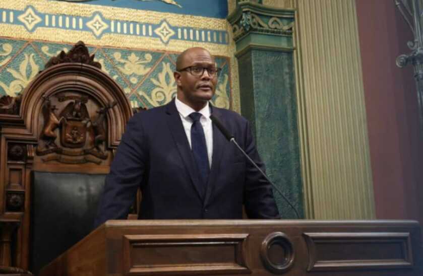 Michigan House Speaker Joe Tate before a lectern.