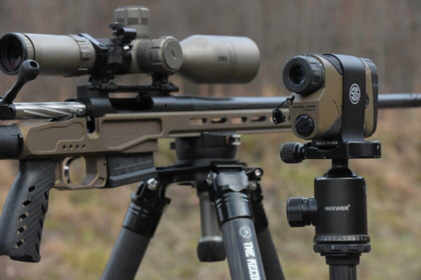 The MgLite sits on a tripod next to a Sig rangefinder at the rifle range.